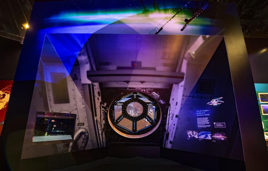 An image from inside the One World Connected exhibit featuring an interactive of the cupola window on the ISS.