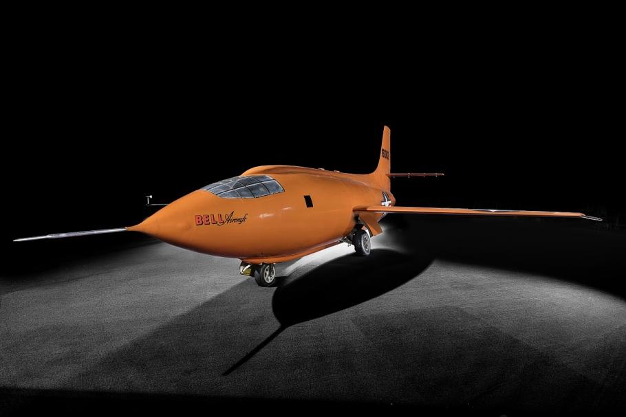 Bell X-1 aircraft photographed from a side angle against a dark backdrop