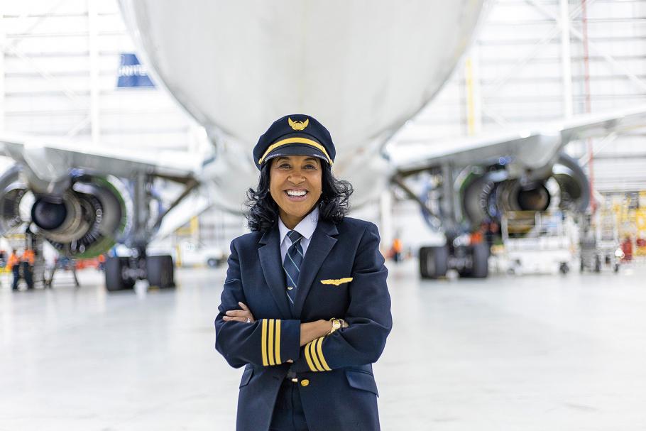 Carole Hopson, wearing her United Airlines uniform, poses in front of one of the Boeing 737s that she flies. She says that when system checks are called out, she makes herself touch the corresponding controls to ensure they are set in the correct positions.