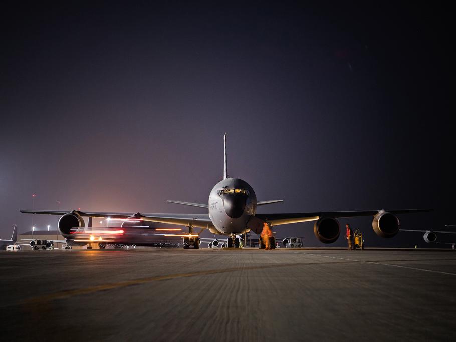 Lights at the Al Udeid Air Base in Qatar illuminate a massive KC-135 Stratotanker as it prepares to taxi before takeoff.