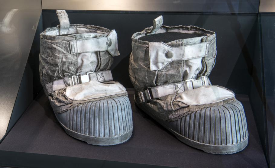 A pair of space boots are on displayed in an enclosed case