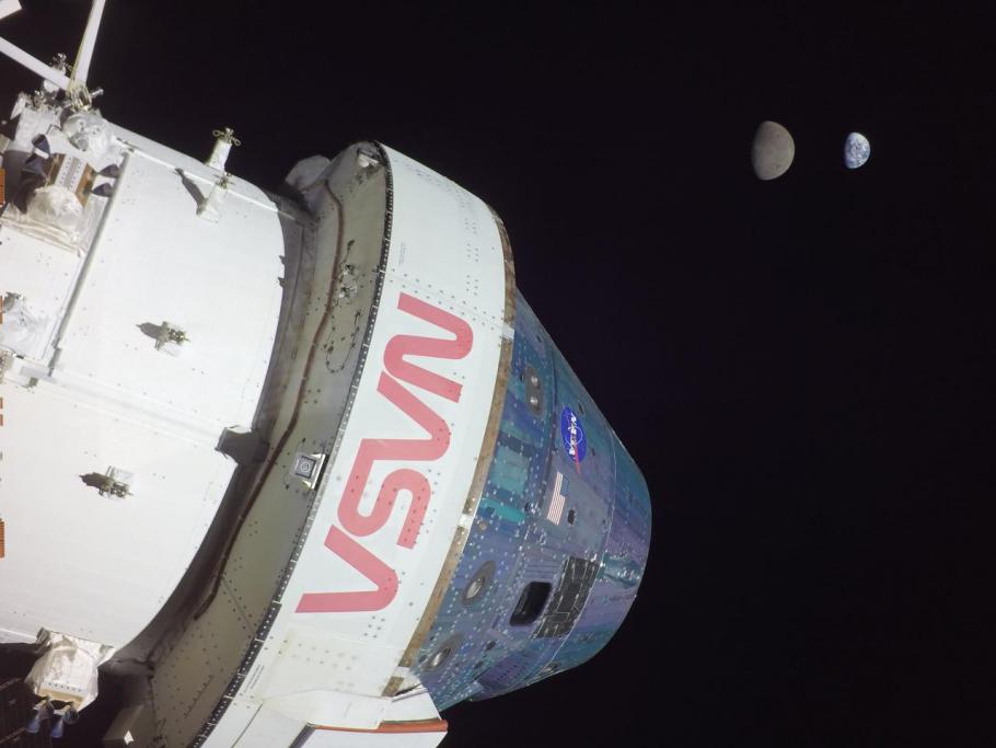 A space capsule is seen at the forefront of the frame while the Earth and Moon is visible in the background.