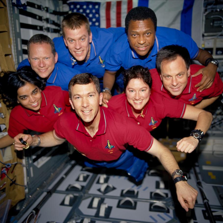 A crew of seven astronauts floating in zero garvity.