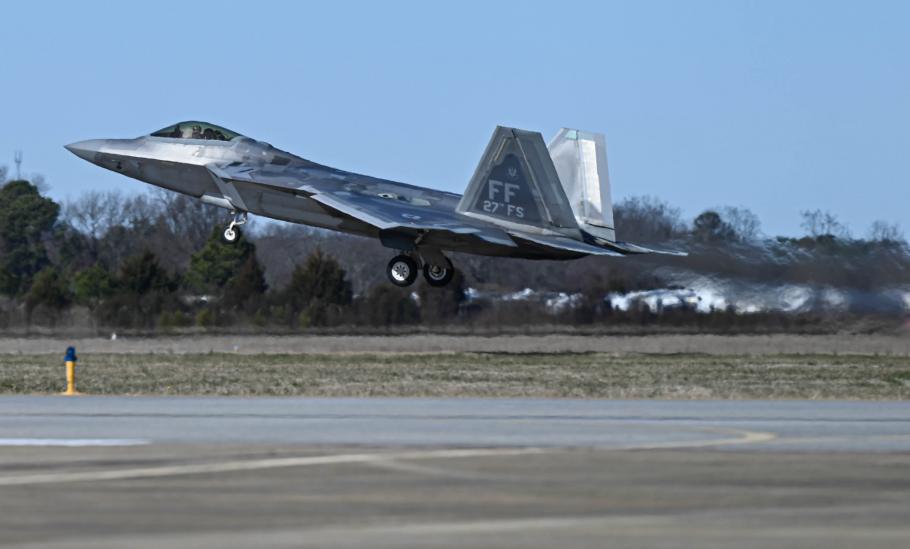 F-22 Raptor fighter jet taking off from a runway.