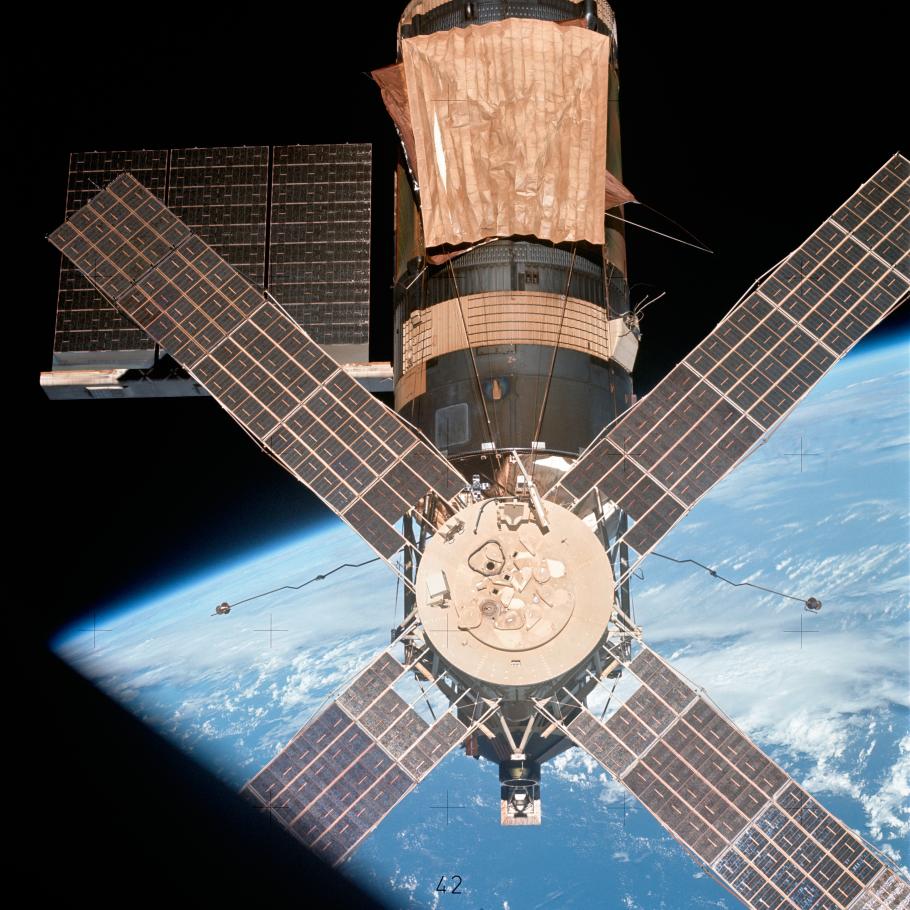 An image of Skylab taken by the third and final crew of astronauts.  The original parasol sunshade installed by the first crew, which is a slightly darker color, can be seen under the twin pole sunshade that was installed by the second crew.