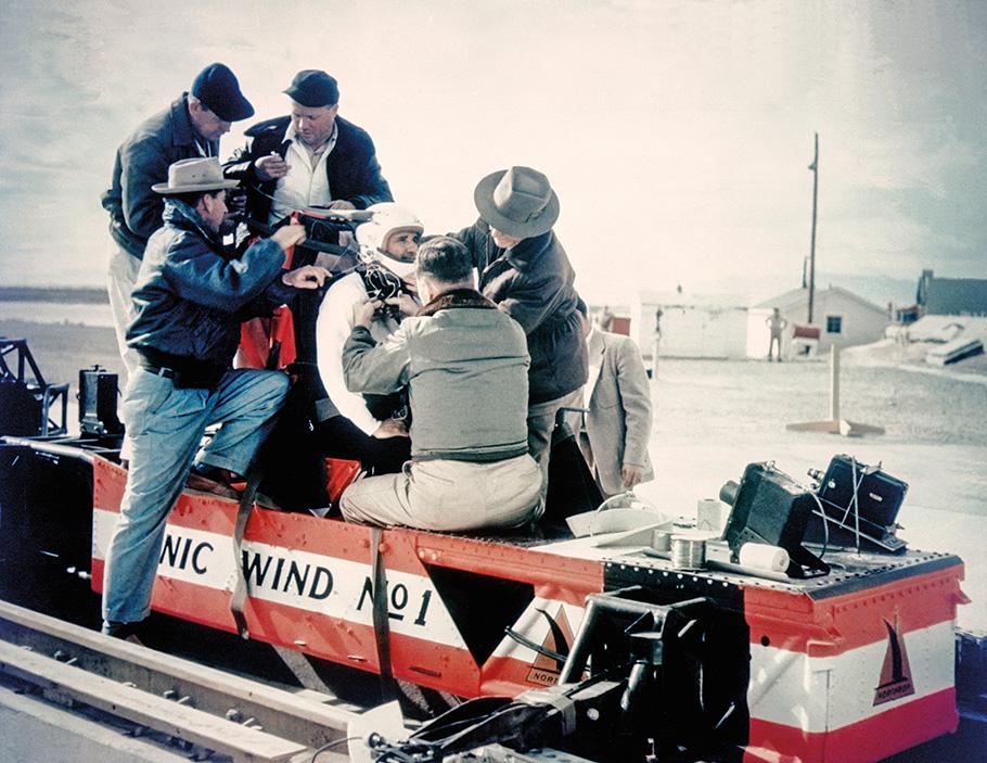 Five workers strap Colonel John P. Stapp to the seat of Sonic Wind No. 1, a ground-based rocket sled.