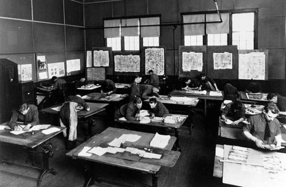 A photo of a group of people sitting at desks inspecting various images.