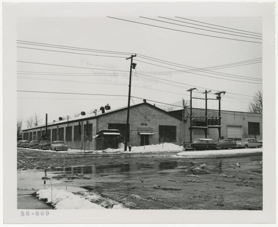 Exterior of a one-story industrial building with a wet, snowy parking lot in the foreground