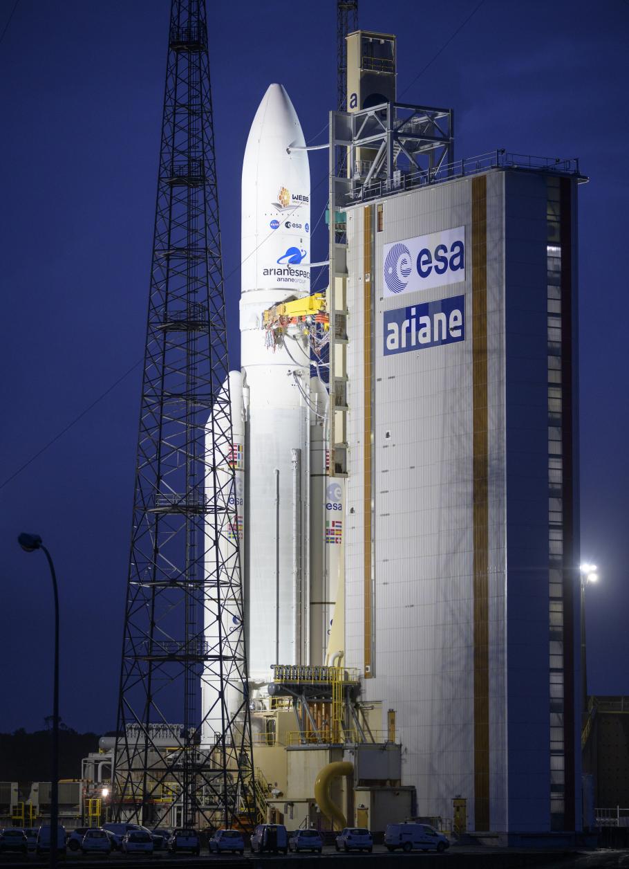 White Ariane 5 rocket on the launch pad. The mobile launcher has large ESA and Ariane logos on it