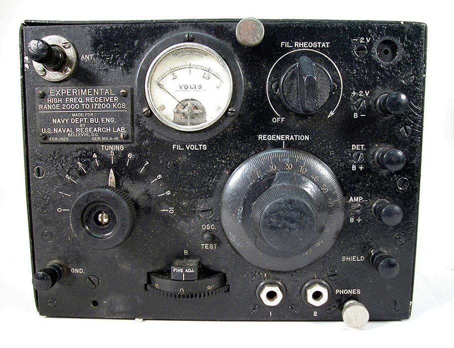 The old black radio has nine dials of varying size and one large white gauge.