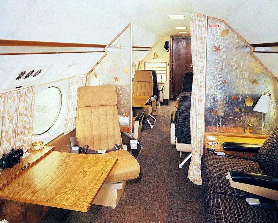 The interior of Disney's aircraft in this photo shows a flying office set up in the 1960s style under the curved roof of the plane.