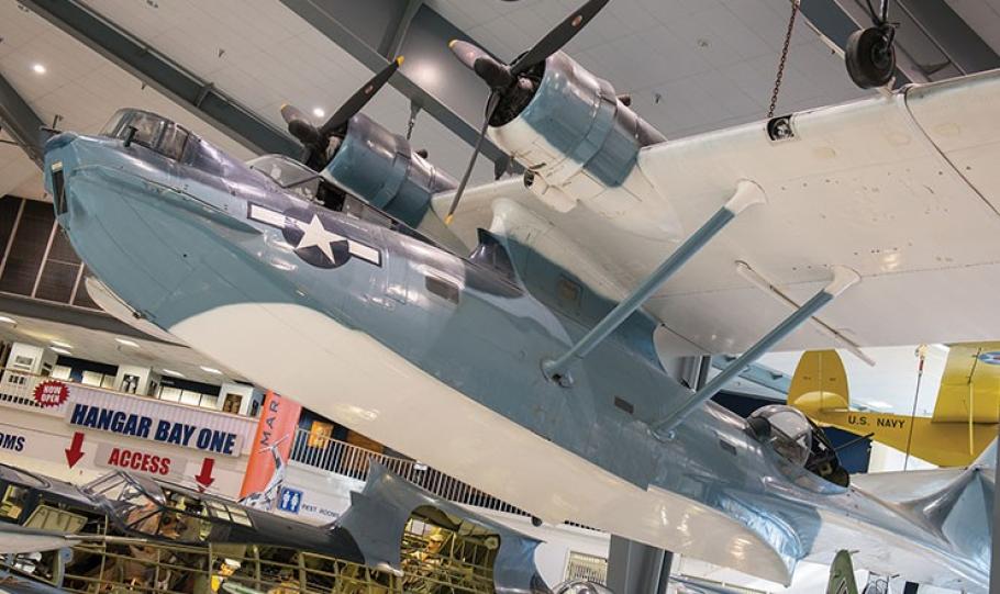 Consolidated PBY Catalina aircraft hangs from the ceiling in a museum setting.