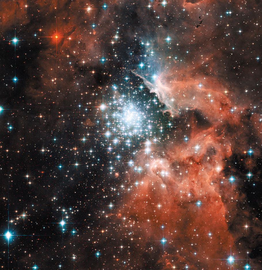 A cluster of thousands of stars shines bright white against the dark background of the cosmos. The cluster is surrounded by shrouds of pink-colored gas.