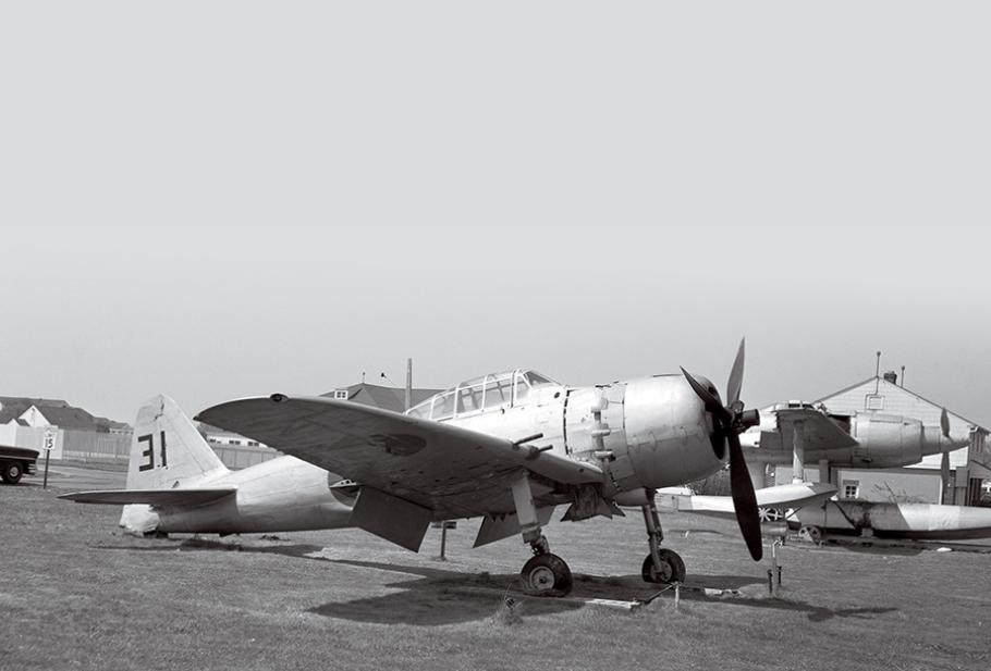 A black-and-white photo of a single-propeller fighter aircraft, with Japanese markings visible on its right wing.