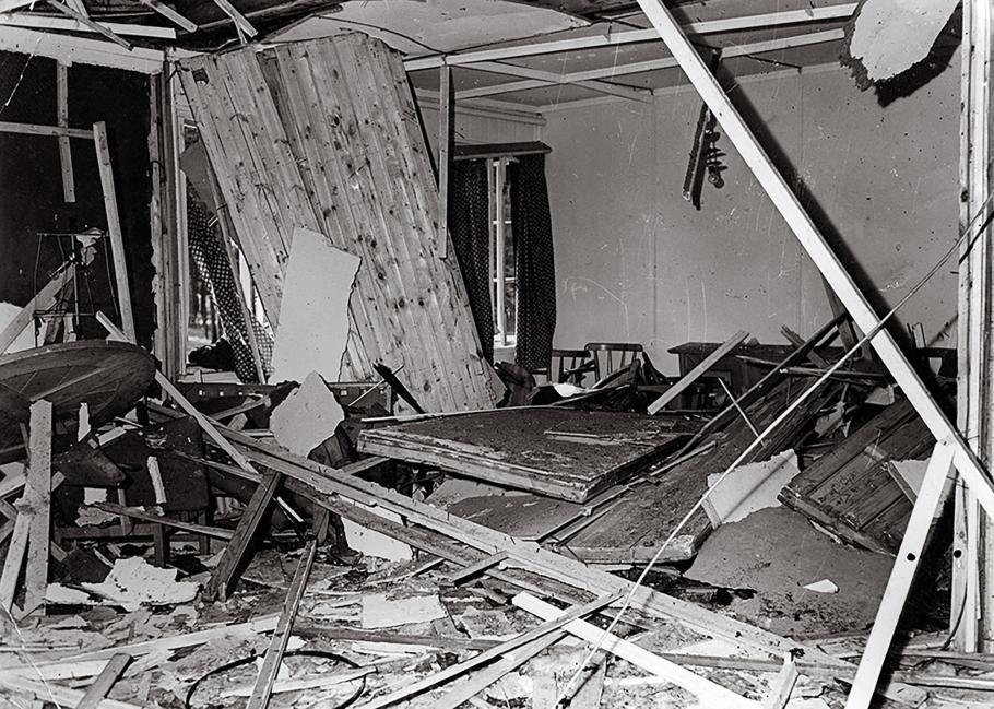 A photo depicts a conference room covered in debris—the aftermath of a bomb exploding during an attempt to assassinate Hitler.