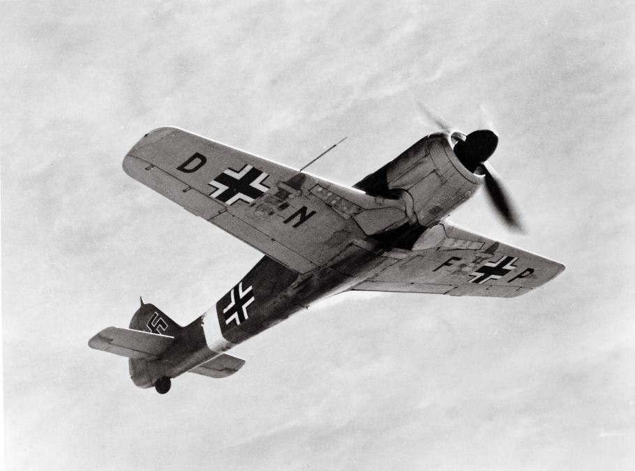 A German fighter aircraft during World War II is tilted upwards as it gains altitude. 