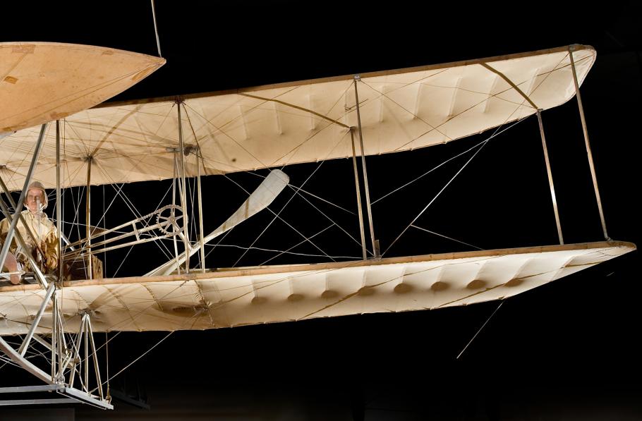 The front view of a vintage biplane's port wings on a black background.