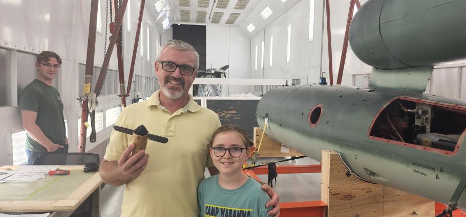 A person holds an airlog propeller in his hand as he poses for a picture.