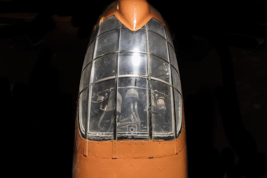 Top view of cockpit of an airplane. The airplane is painted orange and the cockpit window is closed. 