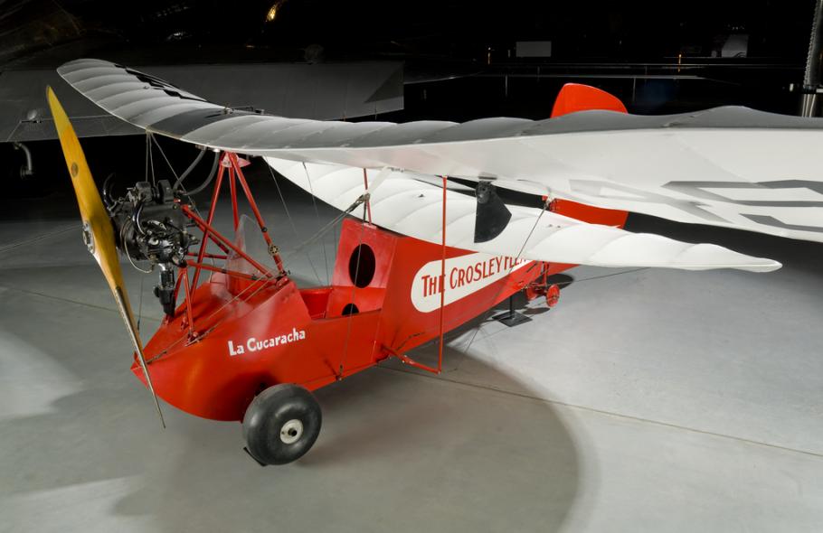 Wing of a red and white open-cockpit staggered wing aircraft 