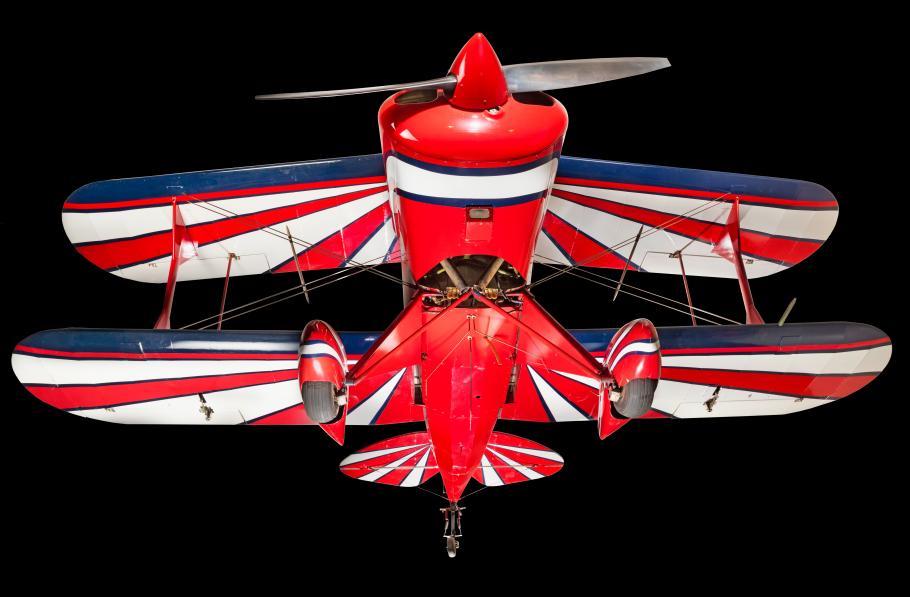 View of the landing gear of a red, white, and blue painted aerobatic biplane. 