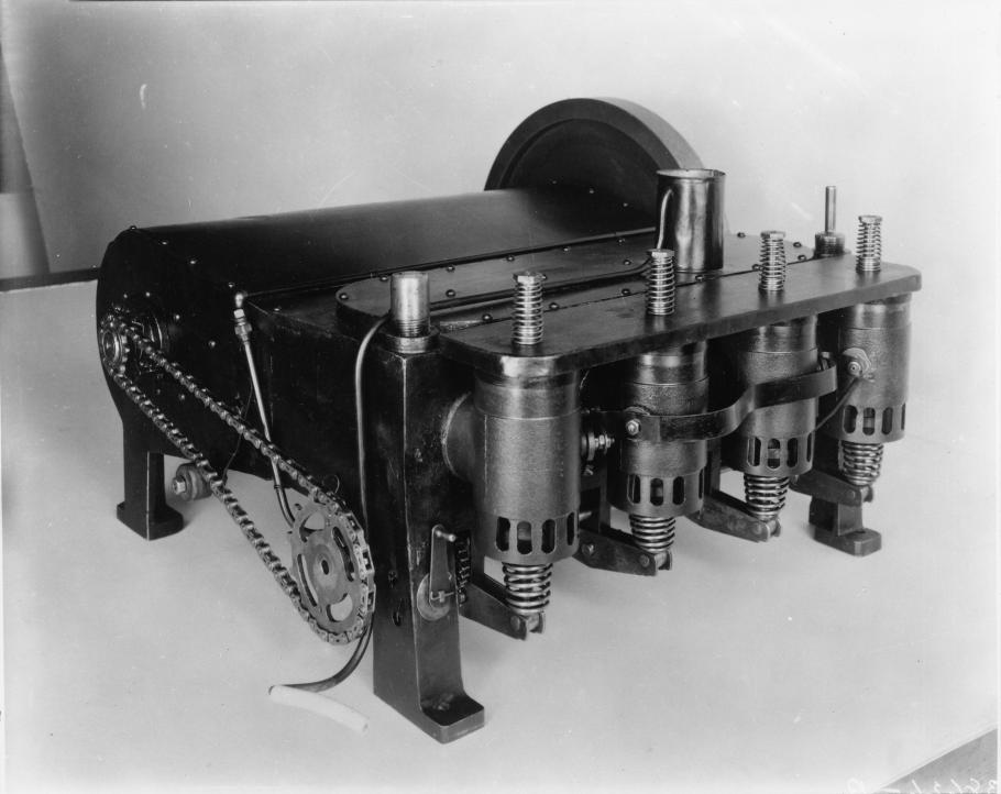 A dark colored box-shaped engine with four cast iron cylinders and an aluminum case.
