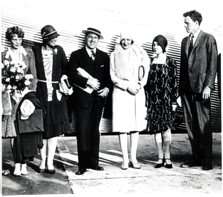 Amelia Earhart, a white woman, stands with other white people including Charles and Anne Lindbergh, featured on the right.