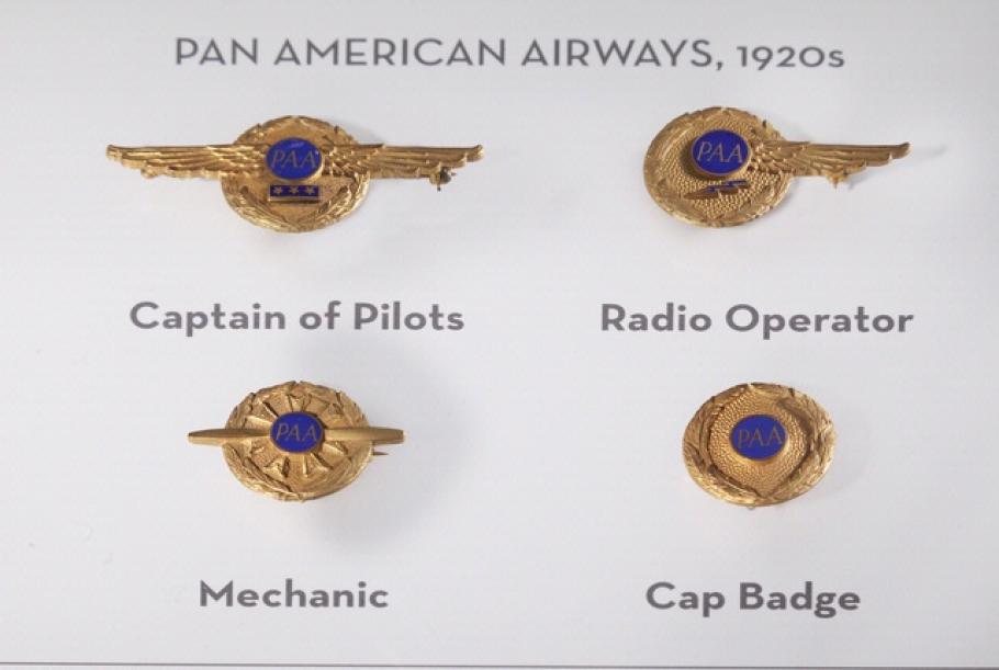 A set of four badges used by Pan American Airways during the 1920s. Each badge features a dark blue circle surrounded by a golden circle.