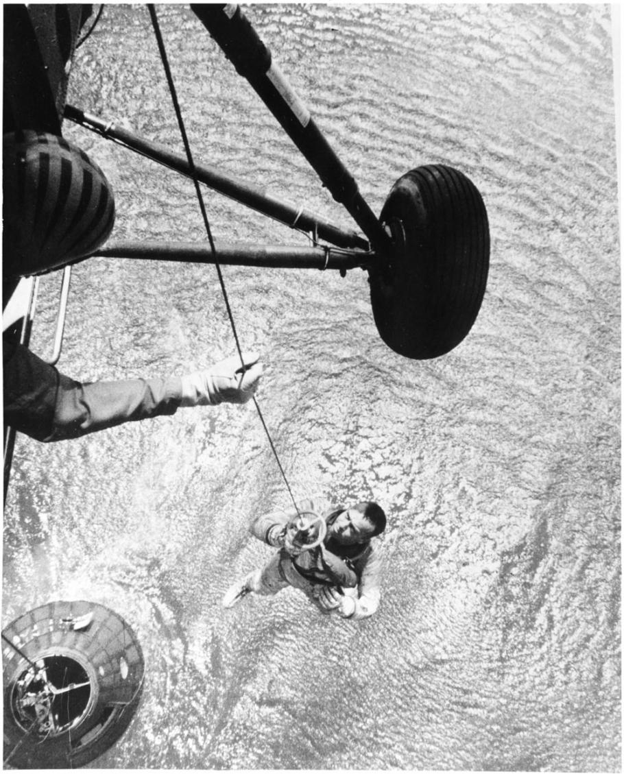 A Navy helicopter hoists Alan Shepard from the ocean after his flight.