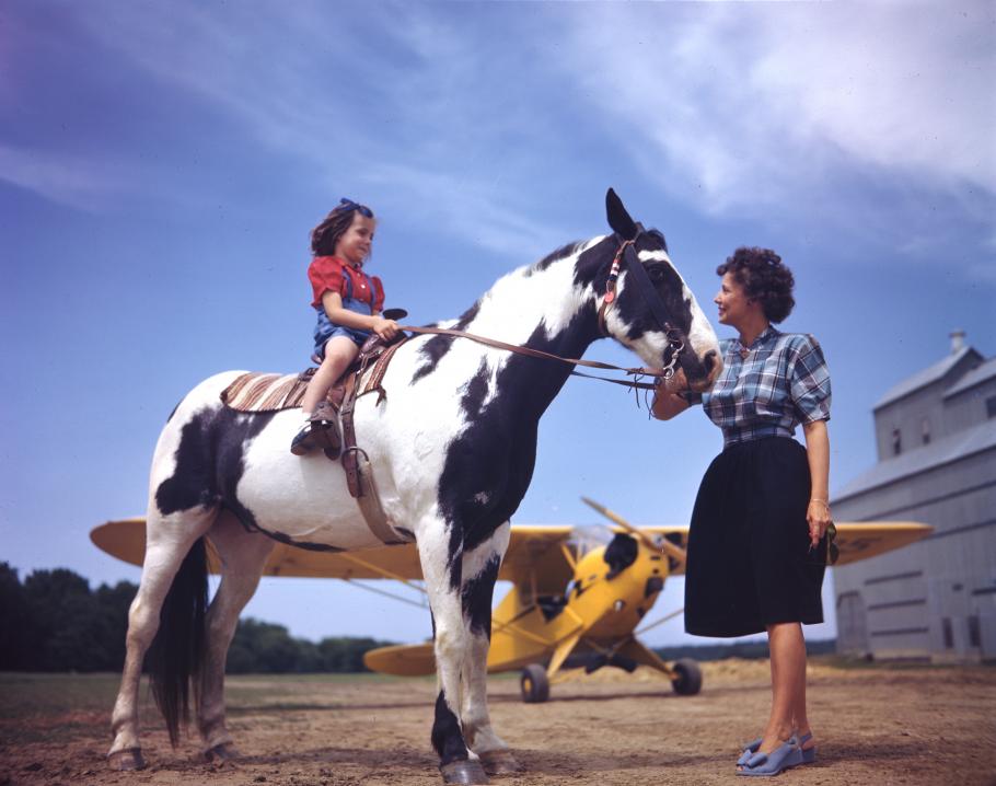 A girl, her pony, and a Piper J-3C Cub