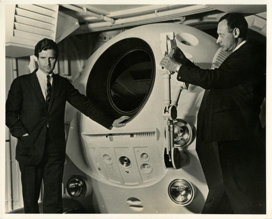 Frederick I. Ordway III (left) and Harry Lange (right) pose with an EVA Pod in the Discovery One pod bay interior set of the motion picture 2001: A Space Odyssey 