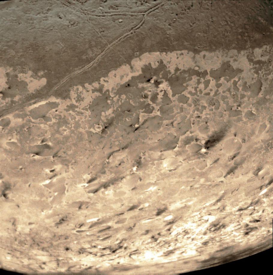 The dark streaks in this image are nitrogen geysers erupting at Triton’s south pole. 