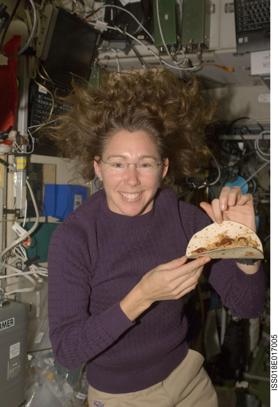 Astronaut Sandra Magnus poses for a photo with a tortilla sandwich which she prepared aboard the ISS.