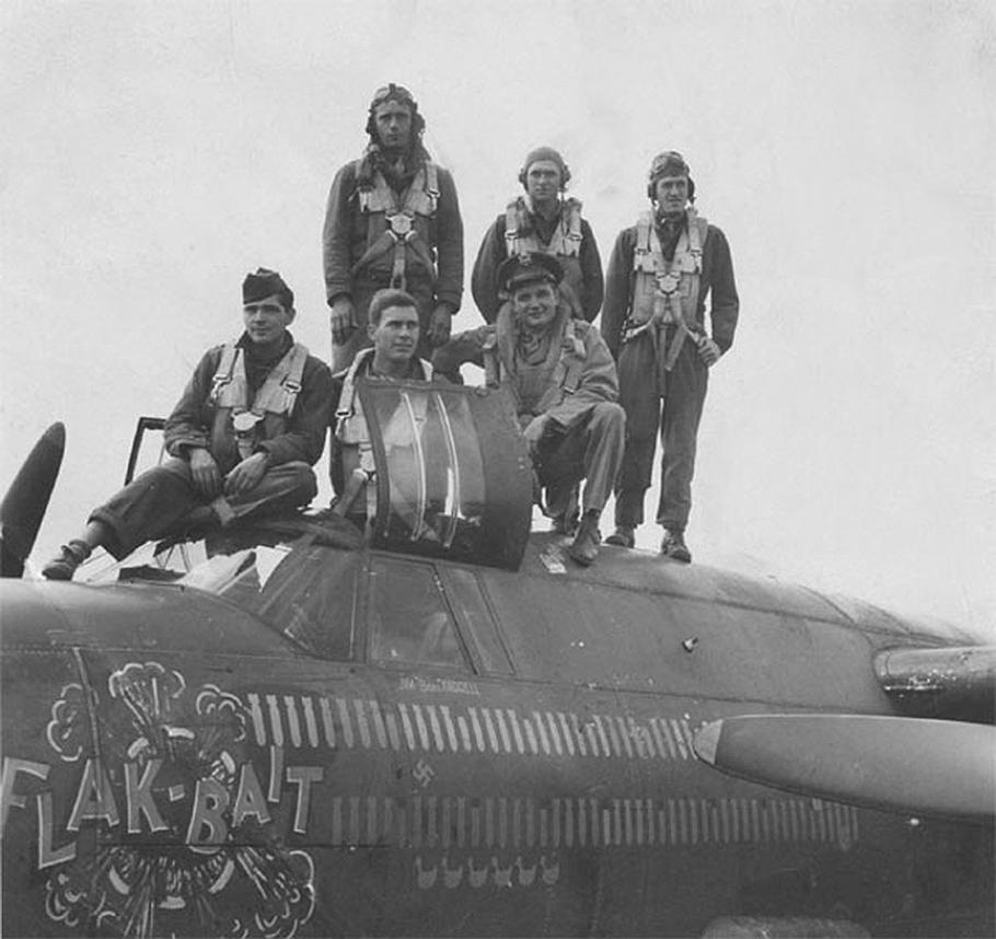Group of men pose on top of aircraft fuselage