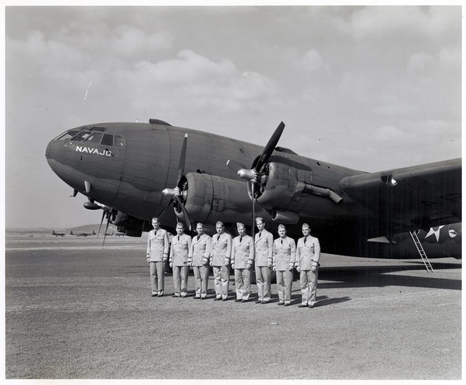 Group of pilots in front of commercial airliner during WWII