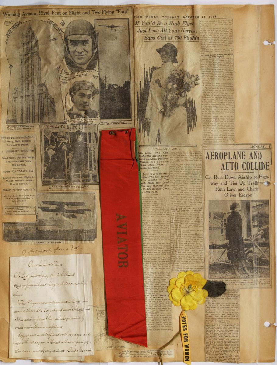 Large Scrapbook page with newspaper clippings. Bottom right, white handwritten sheet; bottom middle; red rectangular ribbon "Aviator"; bottom right: yellow flower attached ribbon "Votes for women"