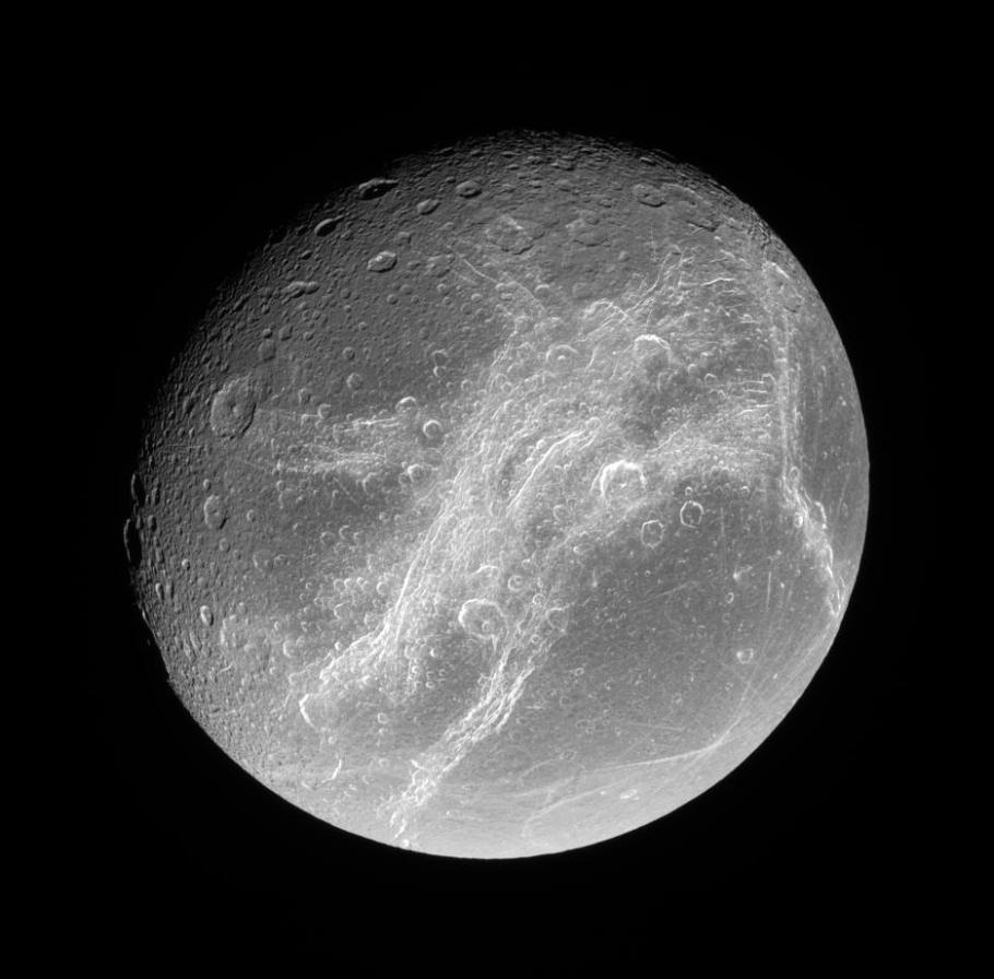 Saturn’s moon Dione. Visible are&nbsp;Dione’s wispy terrains, which scientists believe&nbsp;formed&nbsp;recently. Linear Virgae are found to the east and west of the wispy terrains. 