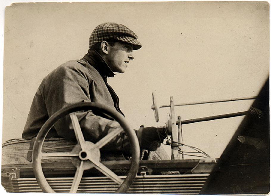 Black and white photo of Hubert Latham sitting at the controls of his aircraft.