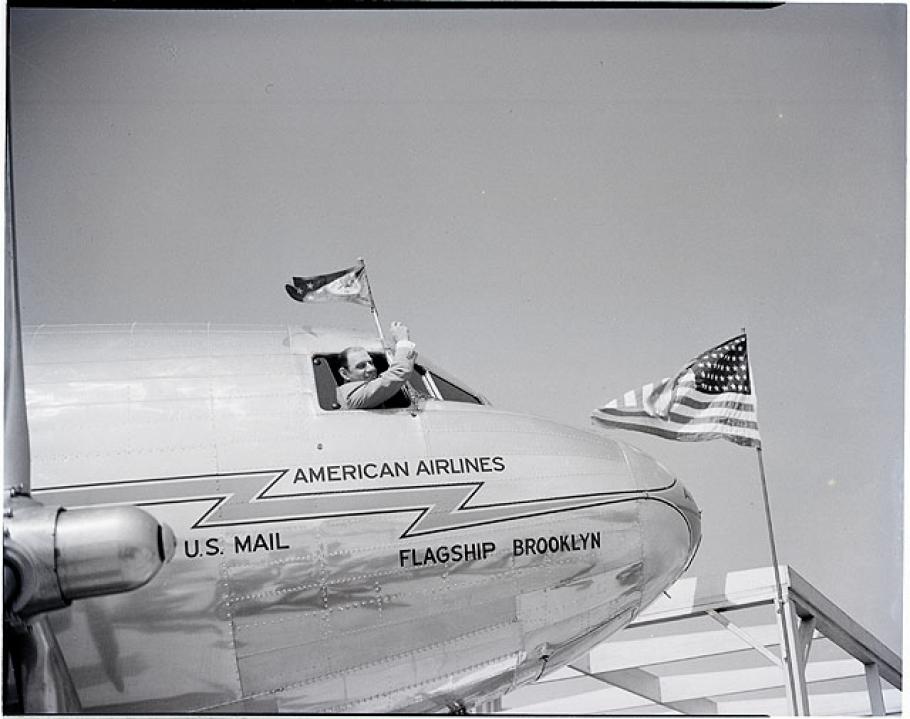 Man waves out the window of a DC-3