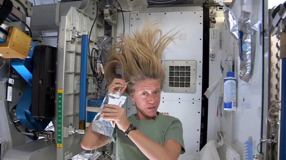 Astronaut demonstrates washing hair in space. 