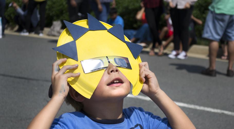 A young visitor at the Udvar-Hazy Center observes the solar eclipse of August 21, 2017 with safe eclipse glasses.