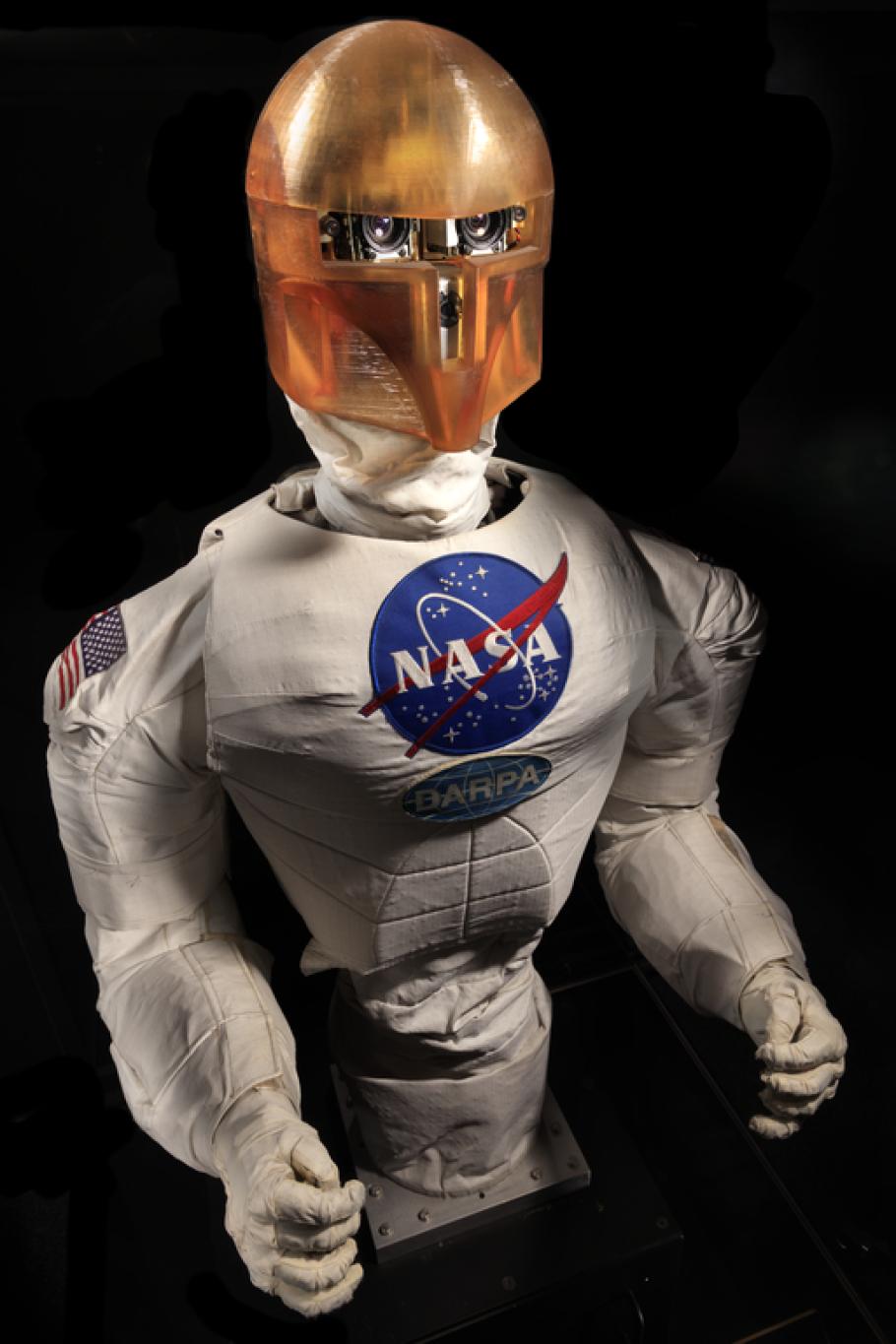 Frontal view of a body of a robot with arms, chest with a NASA logo, and an orange face cover.