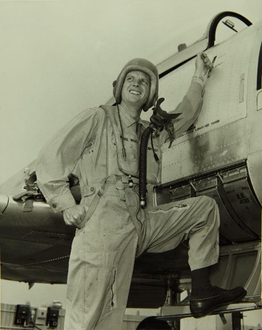 Man in flight suit standing on aircraft