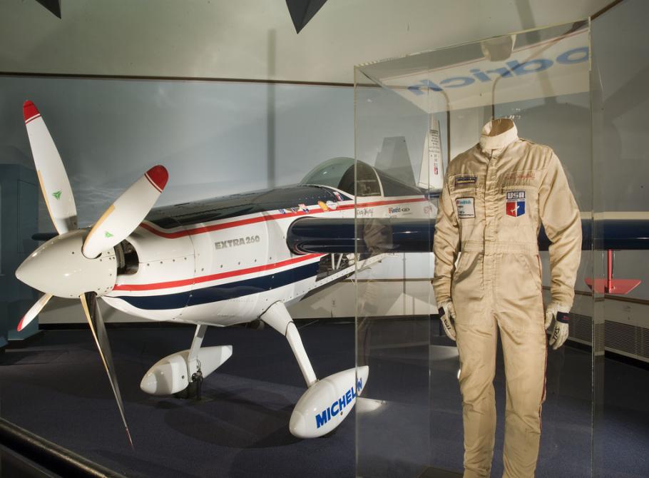 White airplane on display with flight suit next to it