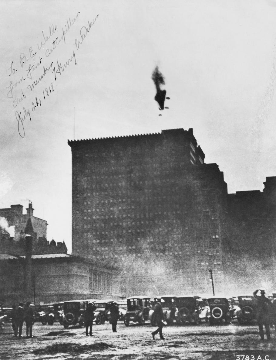 Cars below a building with a crashing airship