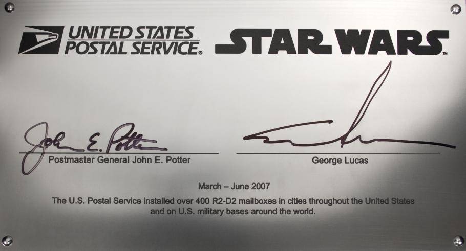 The R2-D2 collection box signature plate, signed by George Lucas and Postmaster General John E. Potter.