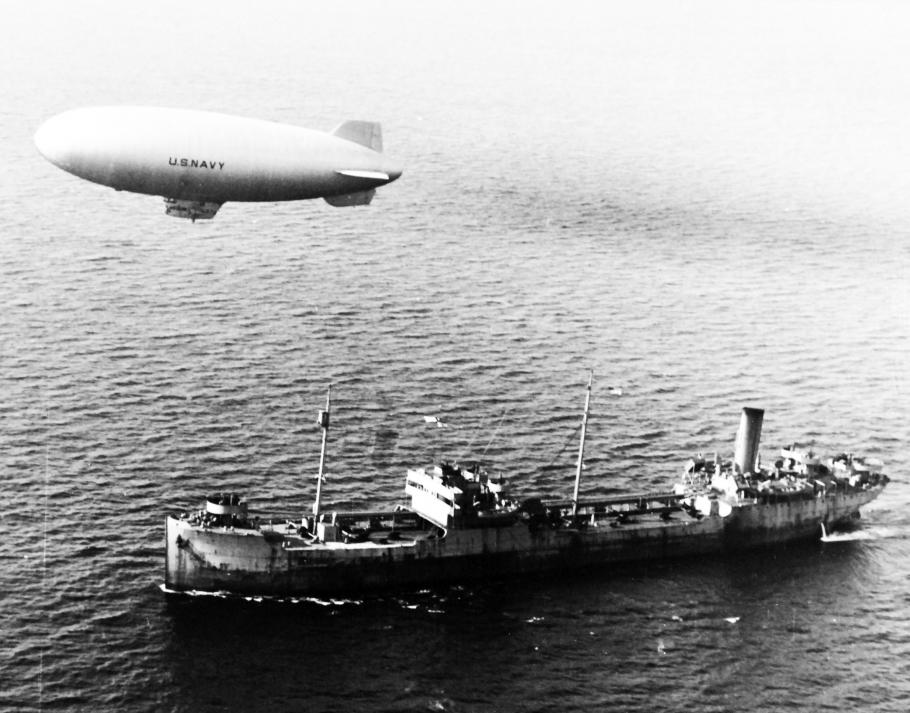 Blimp flying above merchant ship
