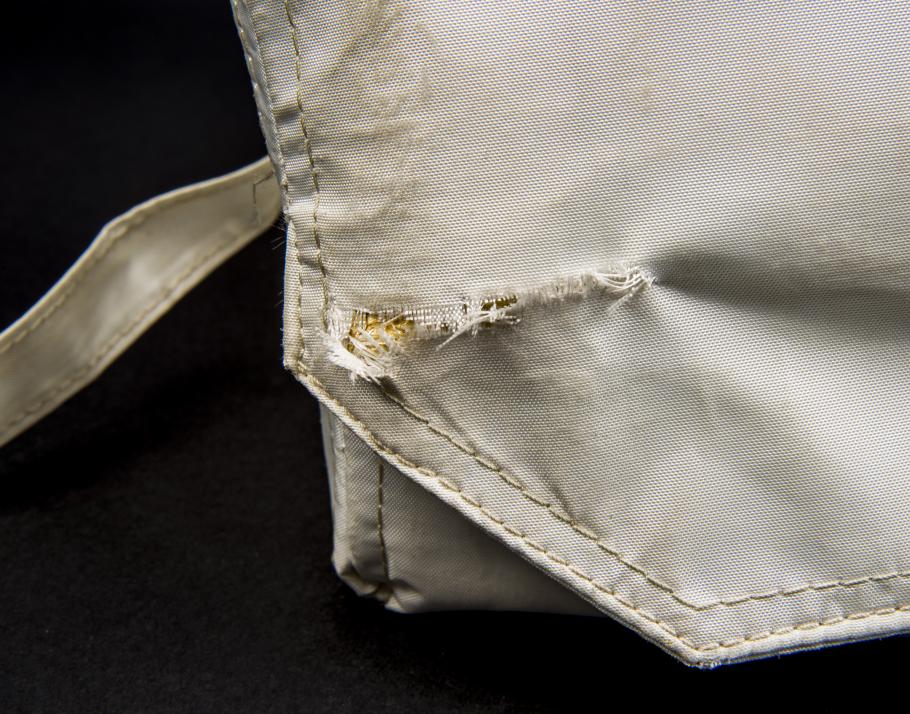 Detail view of the tear to the Beta cloth of the Apollo 11 medical accessory kit. 