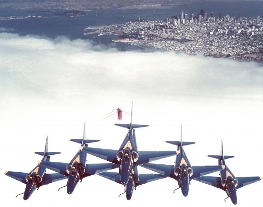 The U.S. Navy Blue Angels in formation flying over the Golden Gate Bridge