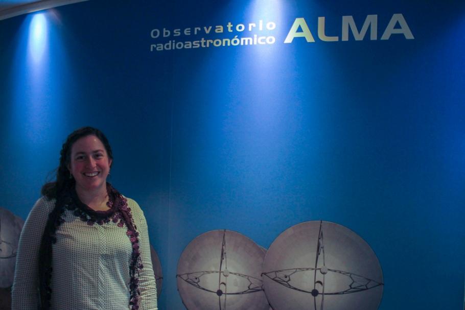 Image of Genevieve in front a sign for the ALMA observatory.